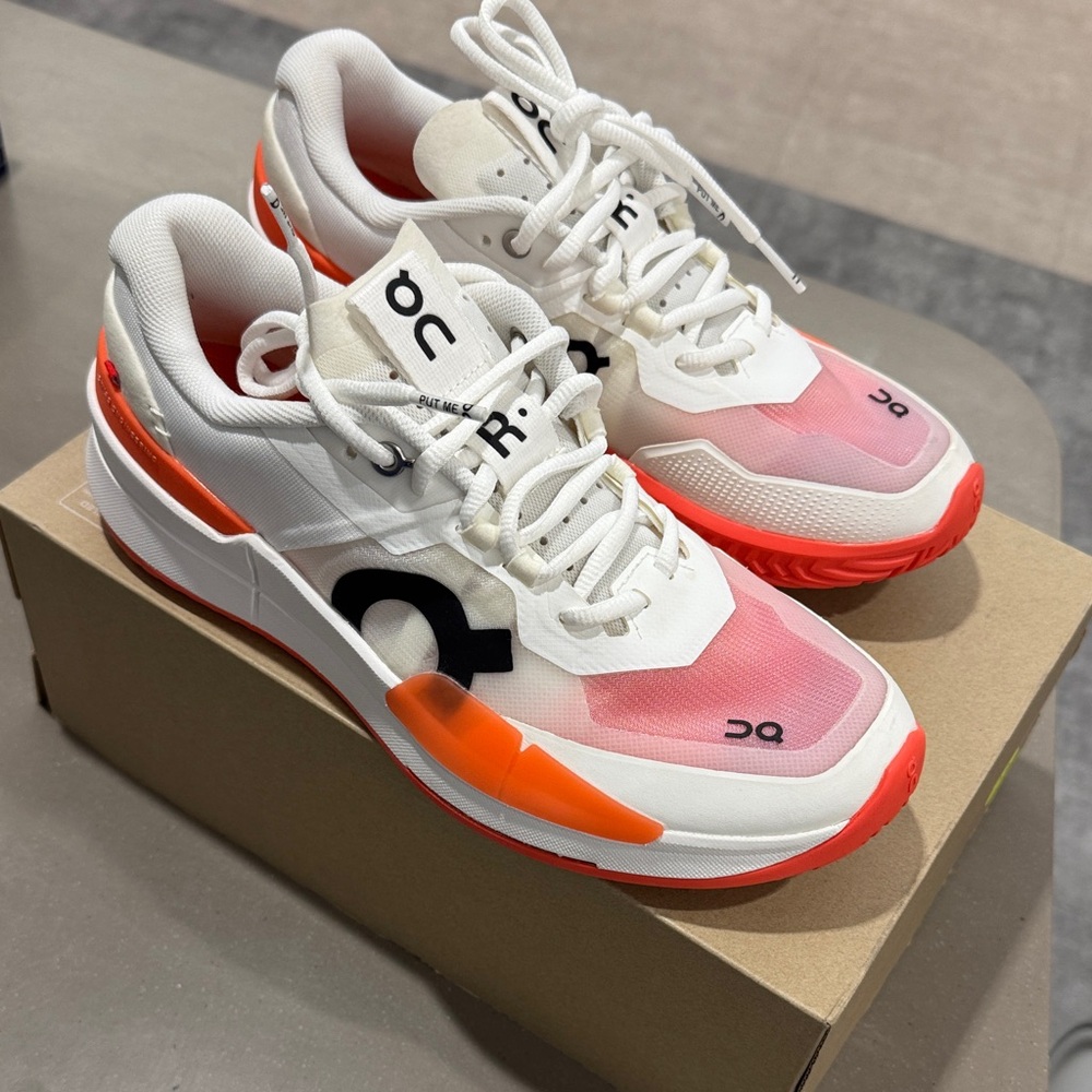 On Running White and Pink Athletic Shoes with Orange Highlights